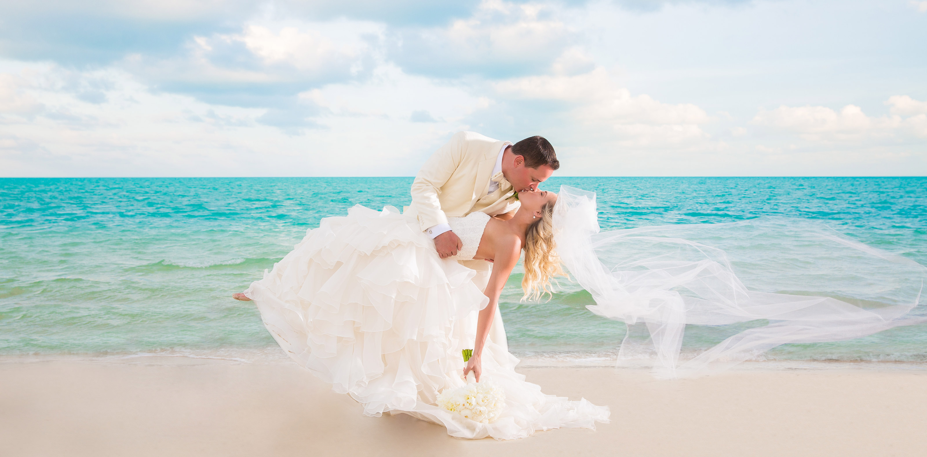 Bride and groom sharing a dip kiss on a Turks & Caicos beach