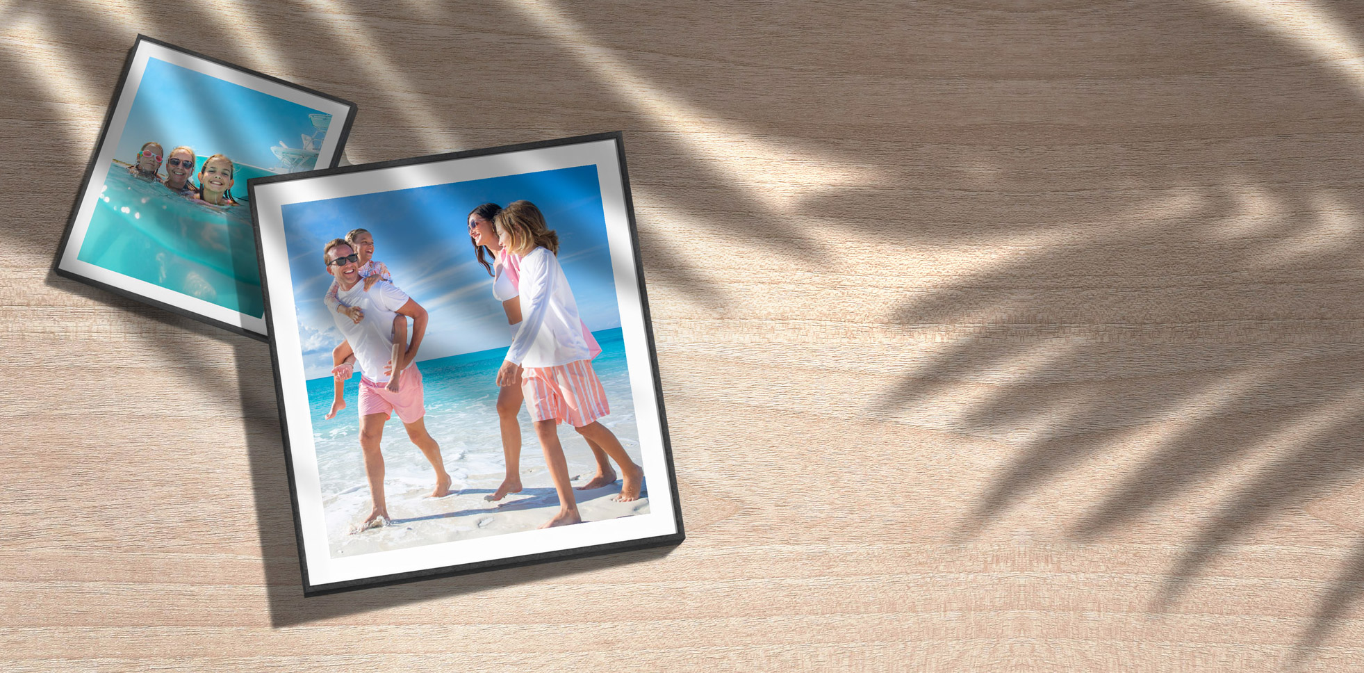 Two framed Paradise Photography prints resting on a wooden table