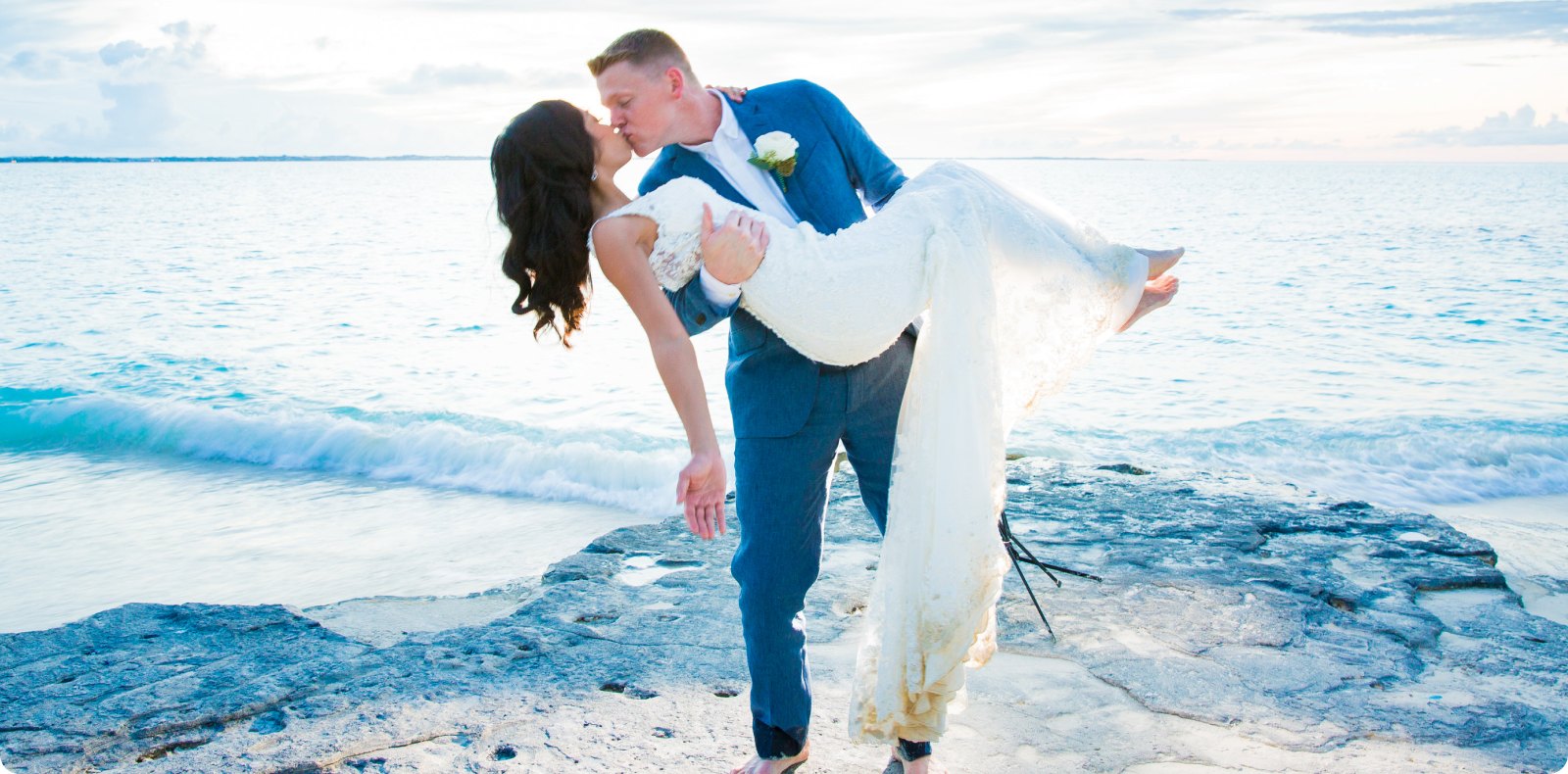 A groom dipping his bride for a kiss on a Turks & Caicos beach